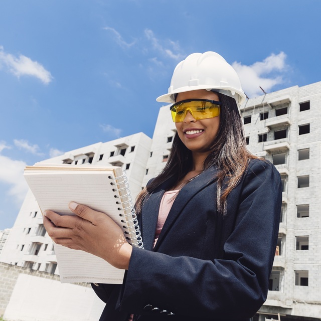 african-american-lady-safety-helmet-with-notebook-near-building-construction